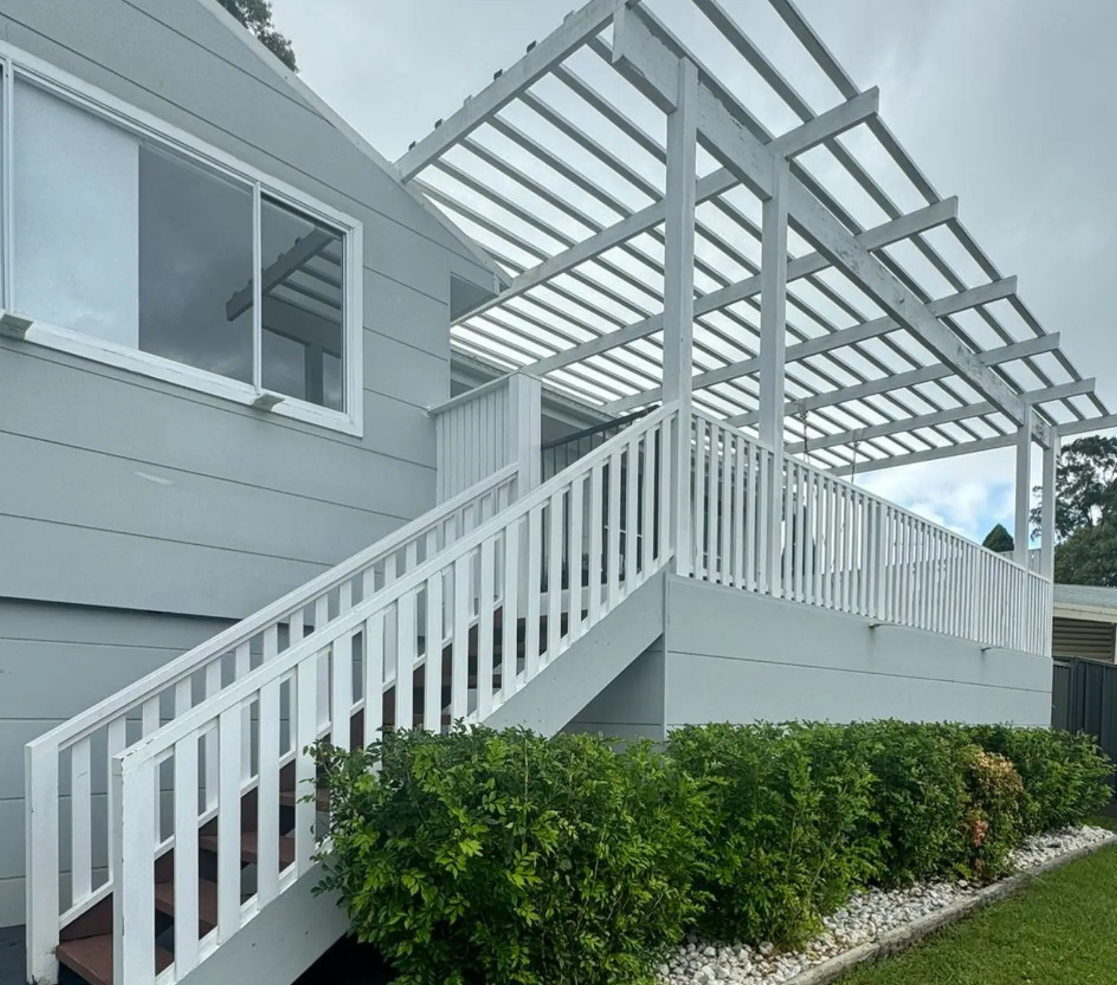 White timber pergola, balustrade and stairs over a raised deck
